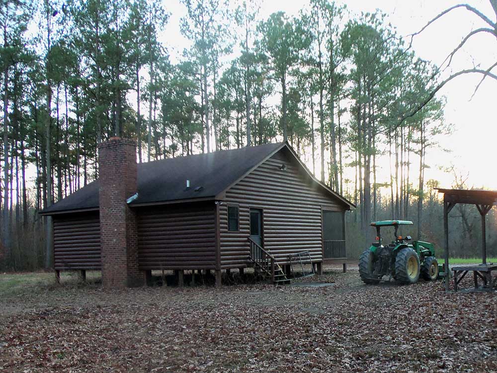 Hunting lodge surrounded by pine trees at Pure Adrenaline Outfitters